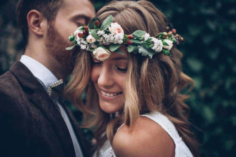 glückliches Hochzeitspaar. Braut mit Blumen im Haar.