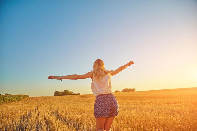 glückliche Frau, die auf Feld geht