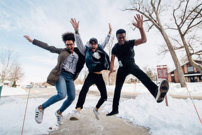 glückliche Freunde springen auf die Straße