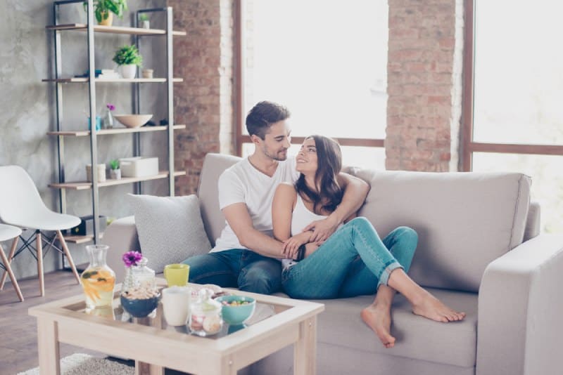 glückliches Paar, das im Wohnzimmer umarmt