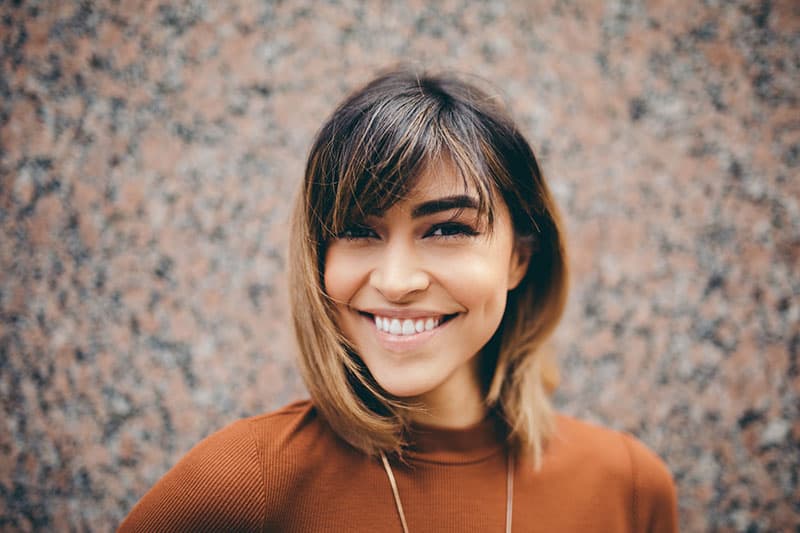 junge Frau mit kurzen Haaren lächelnd
