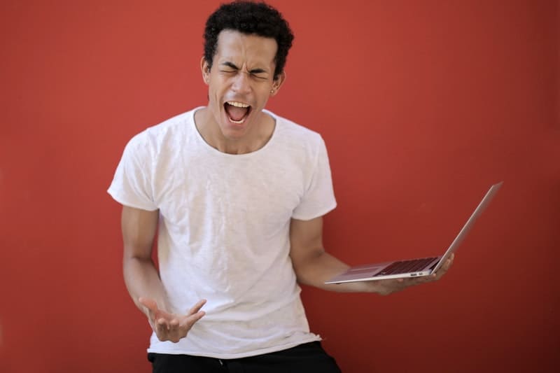junger Mann, der über Laptop brüllt