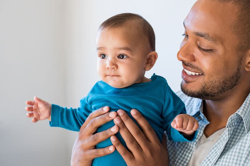 junger Vater hält sein Baby