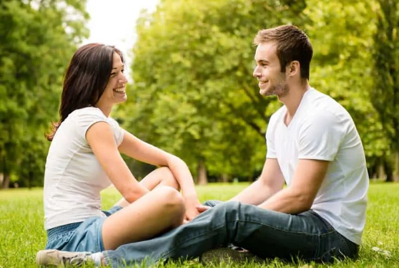 junges Paar, das auf Gras in der Natur sitzt
