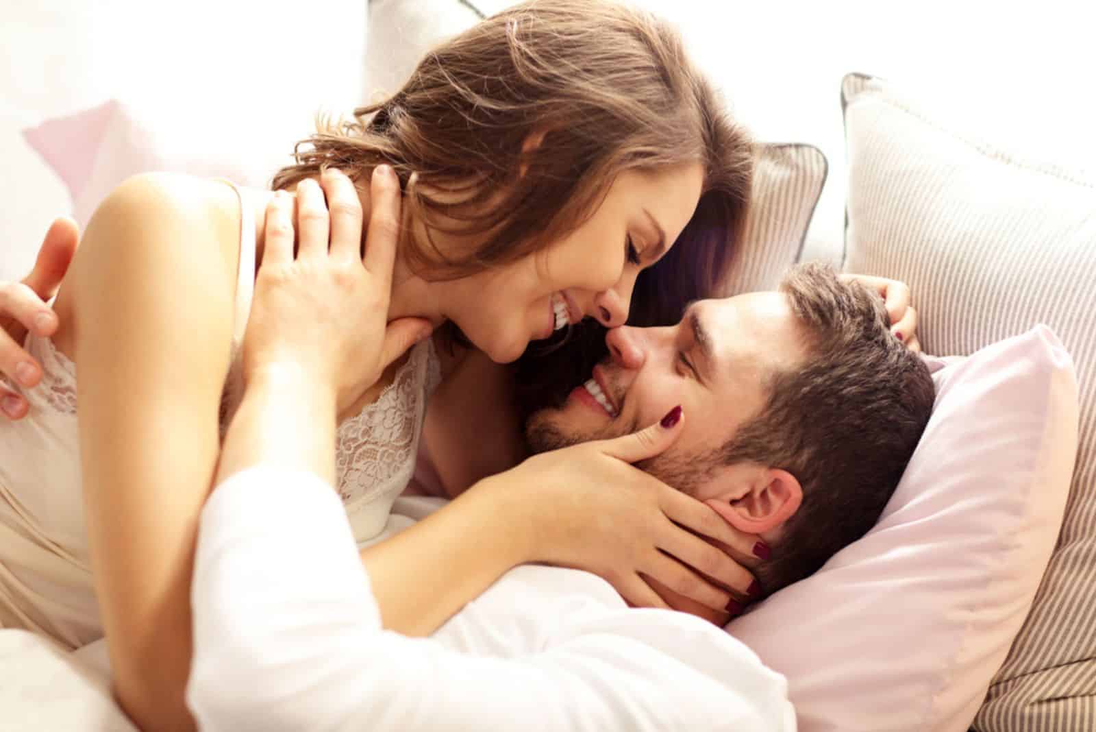 junges Paar küsst sich im Bett