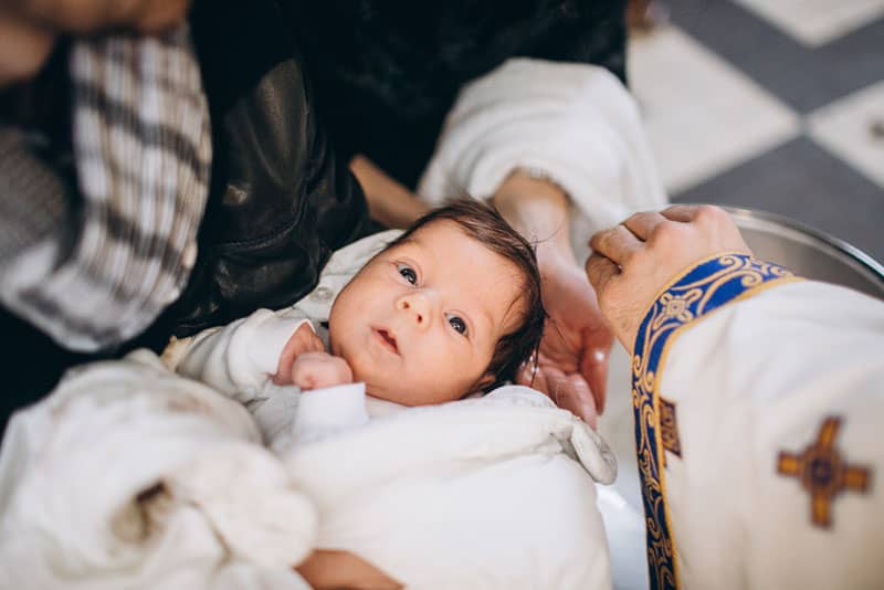kleines Baby bereit für die Taufe in der Kirche
