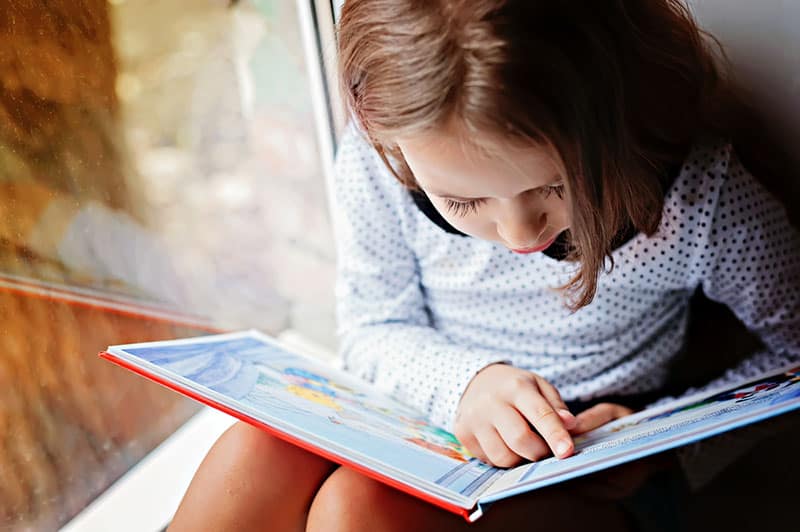 kleines Mädchen liest ein Buch