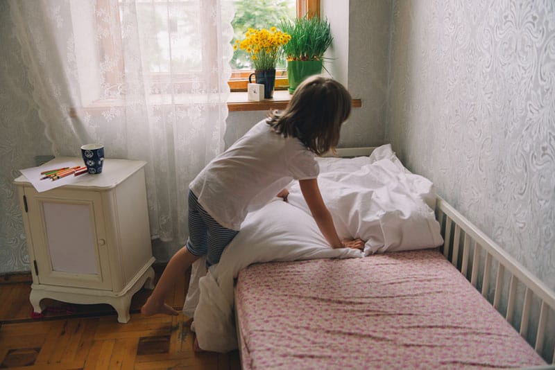 kleines Mädchen putzt ihr Zimmer