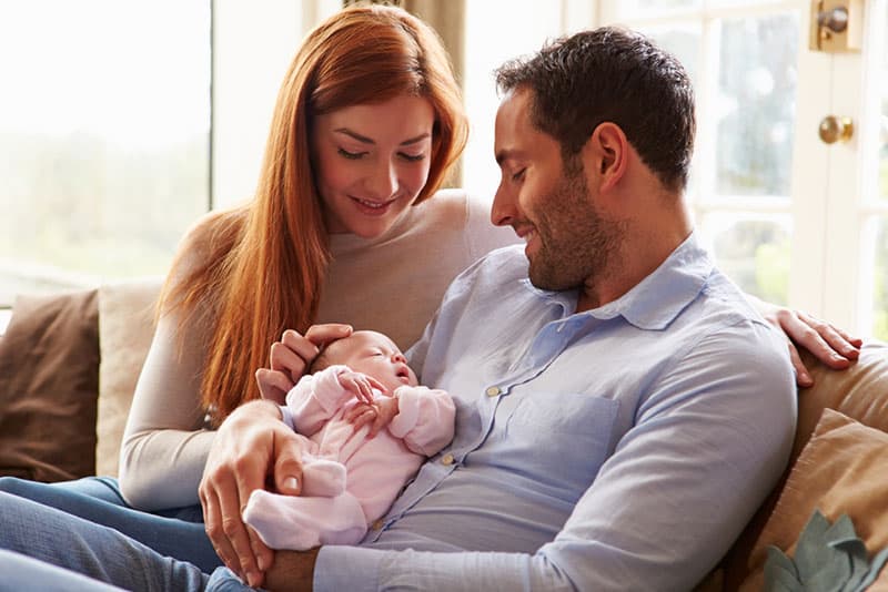 lächelnde Eltern halten ihr Baby
