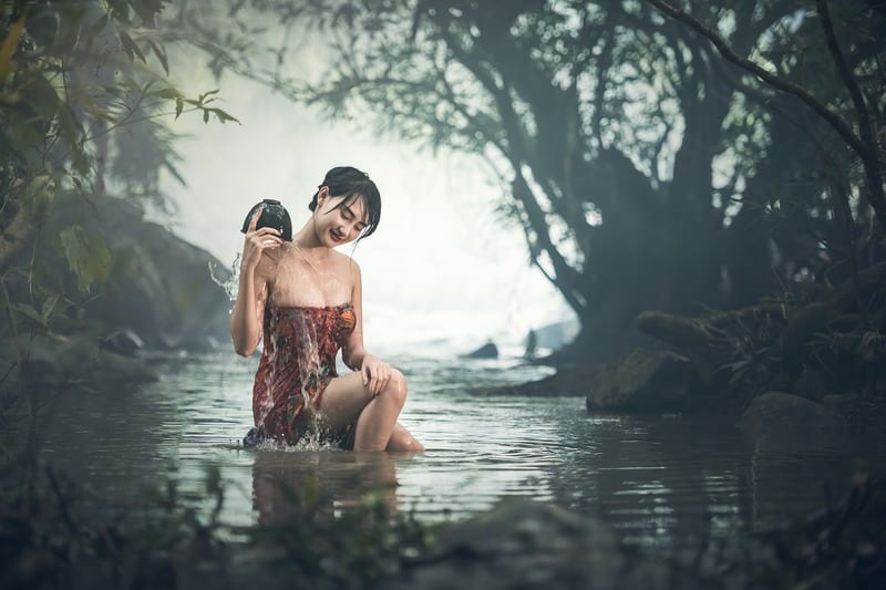 lächelnde Frau badet im See