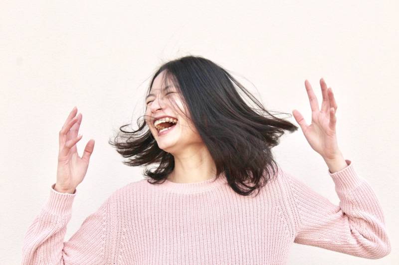 lächelnde Frau, die rosa Pullover trägt