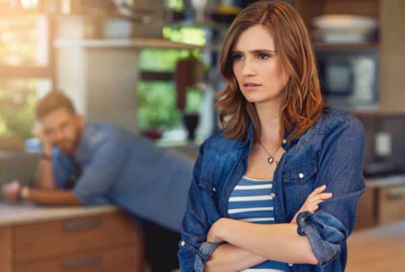 nachdenkliche Frau, die in der Küche steht