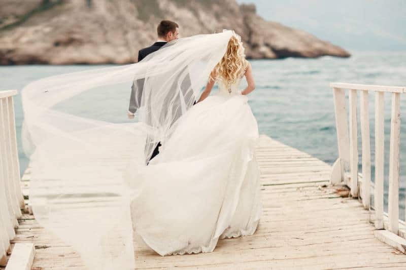 schöne Hochzeitspaar Braut und Bräutigam am Hochzeitstag im Freien am Ozeanstrand
