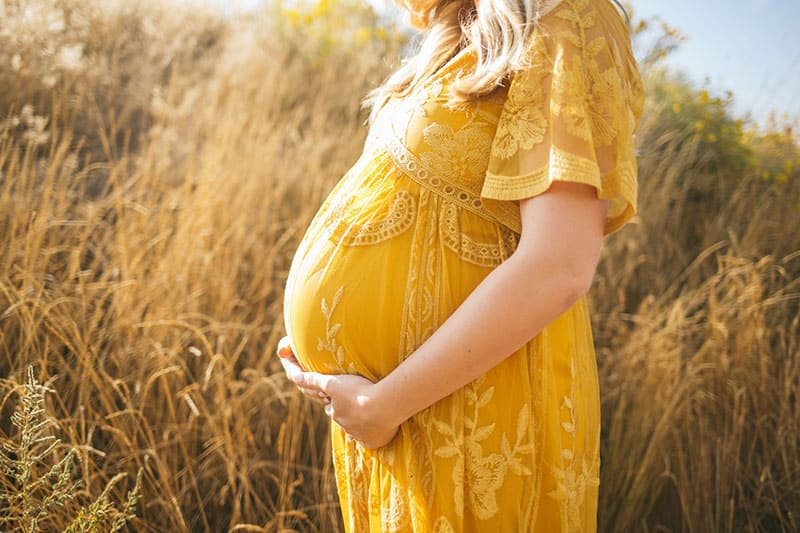 schwangere Frau im gelben Kleid