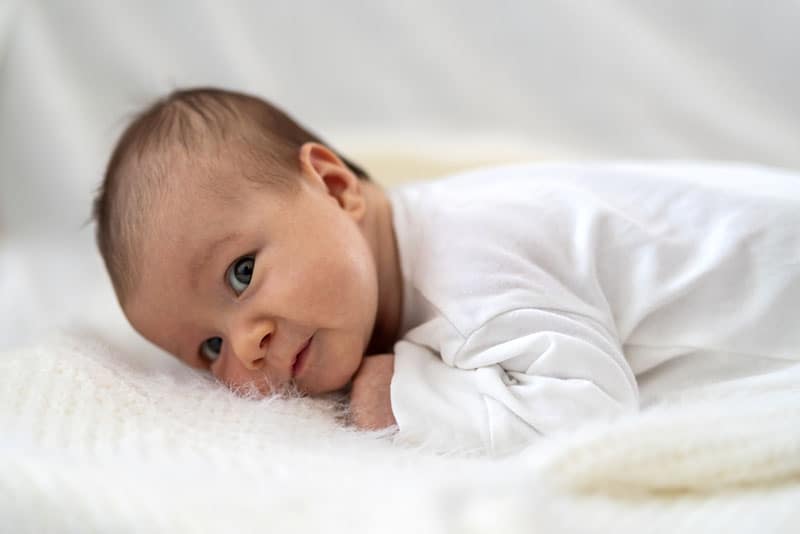 süßes neugeborenes Baby, das auf ihrem Bauch liegt