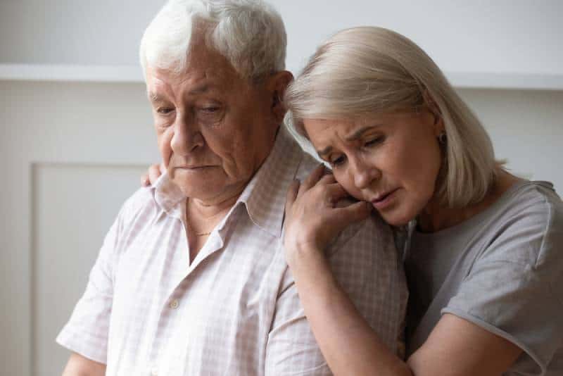 unglückliche Frau mittleren Alters tröstet depressiven älteren Ehemann