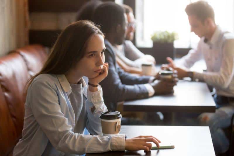 verärgertes Mädchen, das im Café sitzt