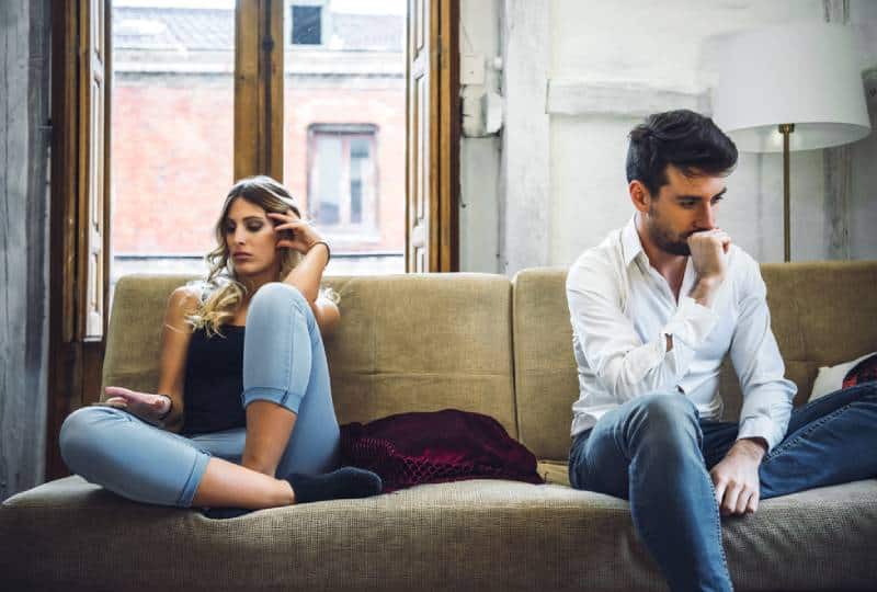 verärgertes Paar sitzt im Wohnzimmer