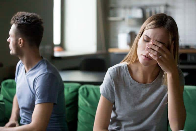 verärgertes Paar sitzt im Wohnzimmer