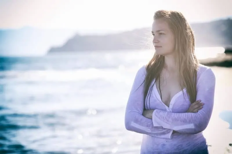 Frau steht am Strand