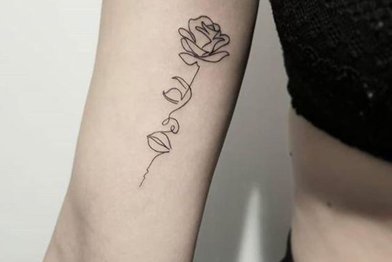 Blume und Gesicht Tattoo auf dem Arm