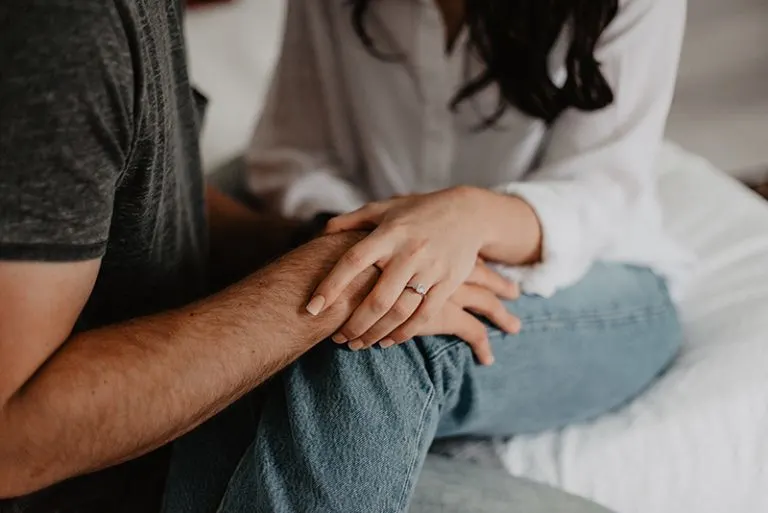 eine Frau, die die Hand eines Mannes berührt, um Vertrauen zu zeigen