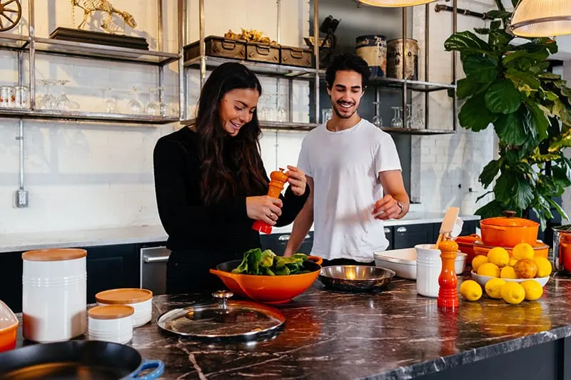 Ein Mann und eine Frau bereiten gemeinsam in der Küche Essen zu