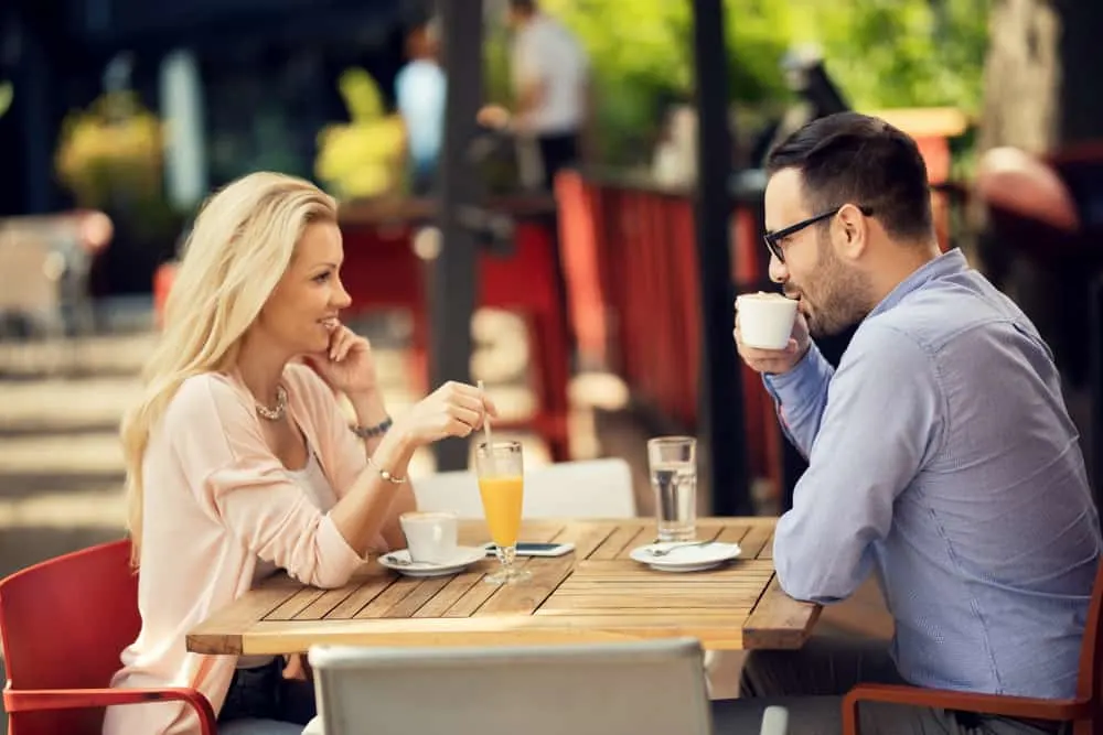 Ein Mann und eine Frau sitzen, trinken Kaffee und schauen sich an