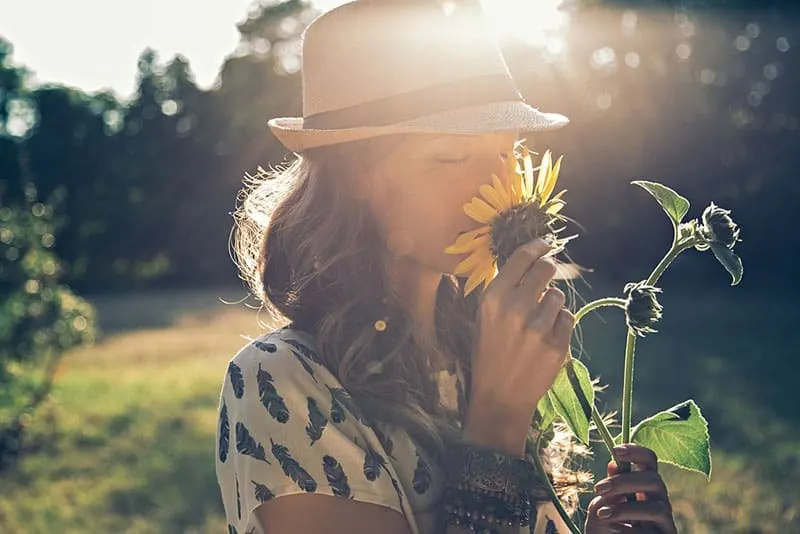 Frau riecht an der Sonnenblume