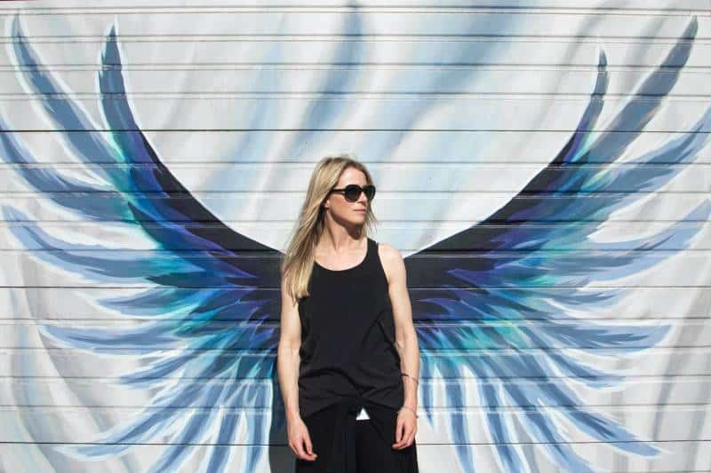 Frau, die Foto nahe Flügel gemalte Wand nimmt