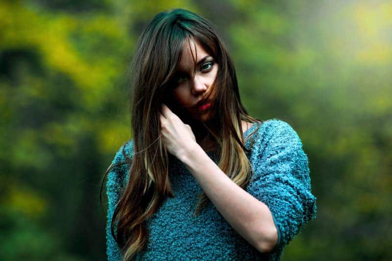 Frau mit blauem Pullover draußen stehend