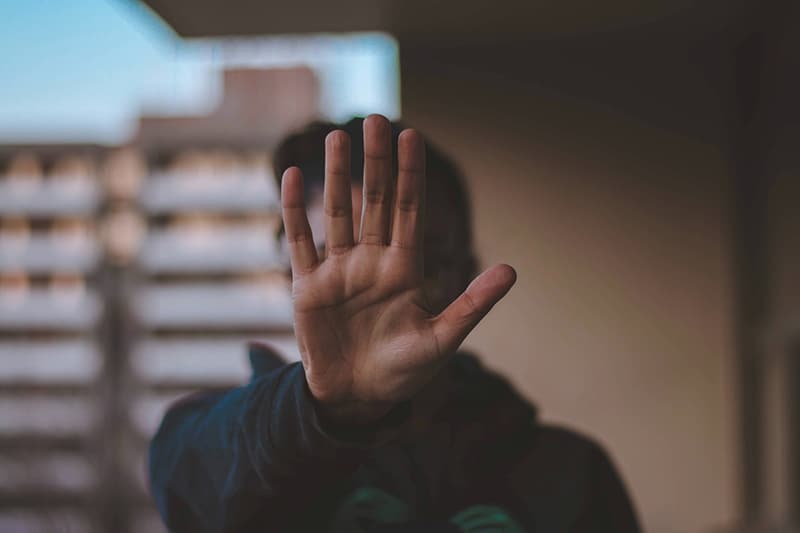  Frau zeigt Stopp mit ihrer linken Handfläche während des Stehens