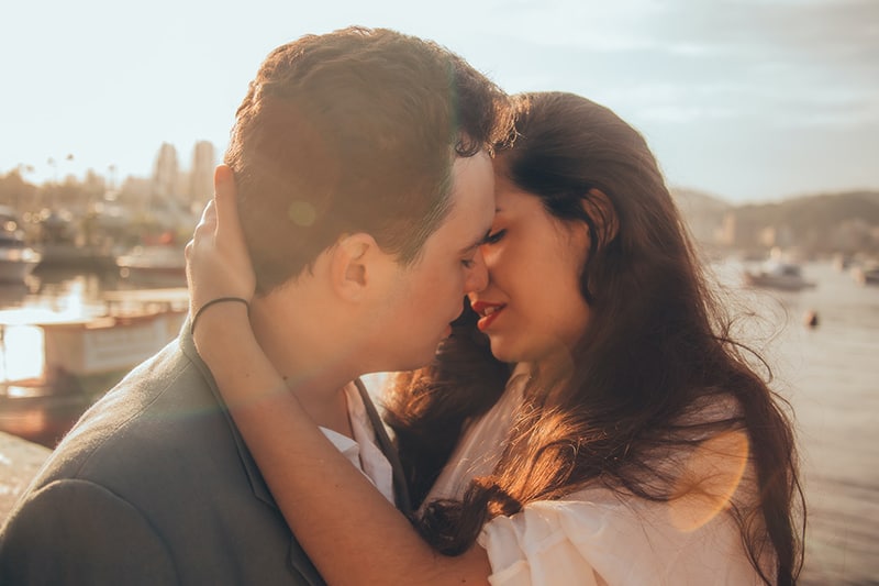  Mann und Frau küssen sich neben der Bucht Während der Tageszeit
