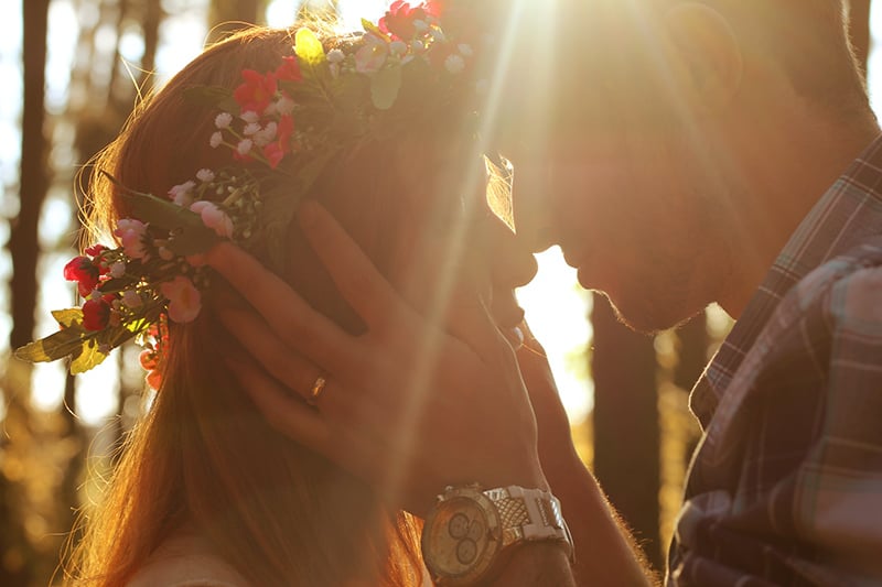  Mann und Frau küssen sich während des Sonnenuntergangs