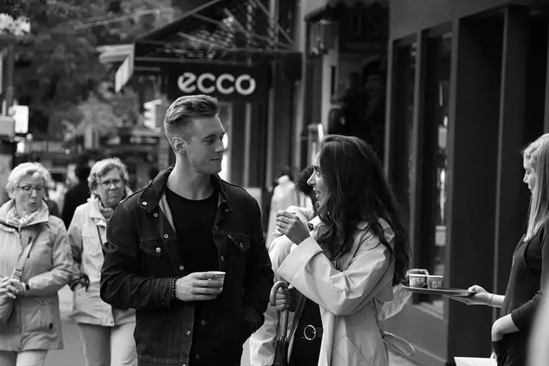  Mann und Frau trinken Kaffee auf dem Bürgersteig