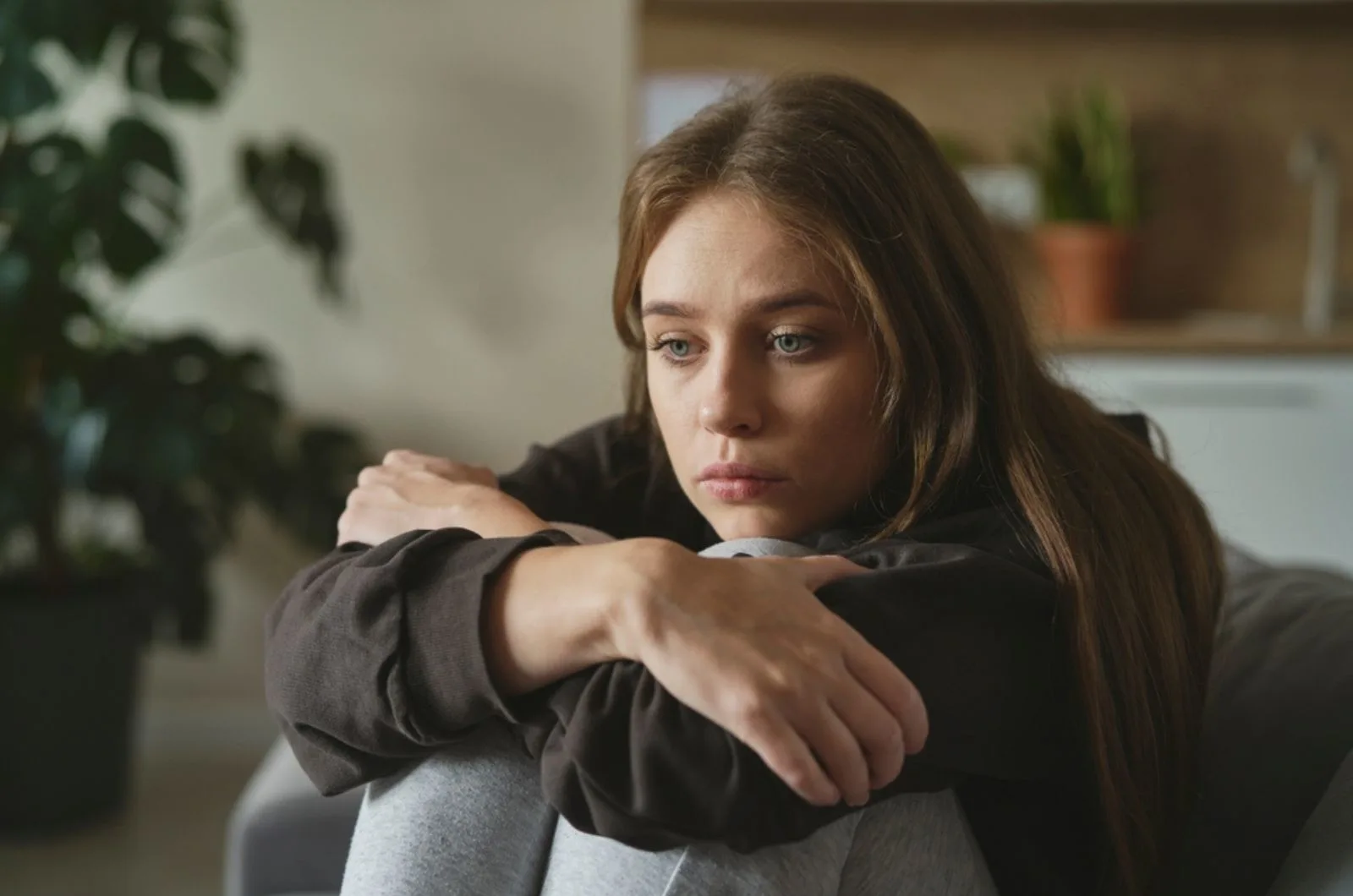 traurige junge Frau sitzt in ihren Gedanken