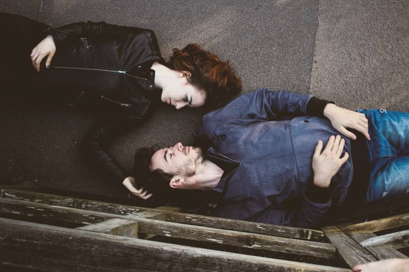 Paar liegt auf dem Straßenboden und schaut sich an