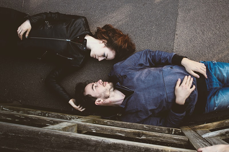 Ein Mann und eine Frau sehen sich an, während sie auf dem Boden liegen