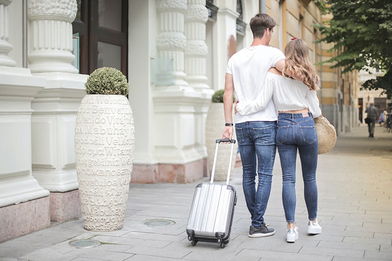 Ein liebevolles Paar auf einer romantischen Reise mit Gepäck auf der Straße