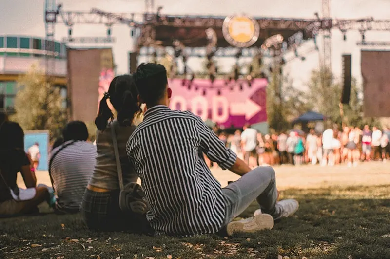 ein liebendes Paar beim Konzert im Gras sitzen