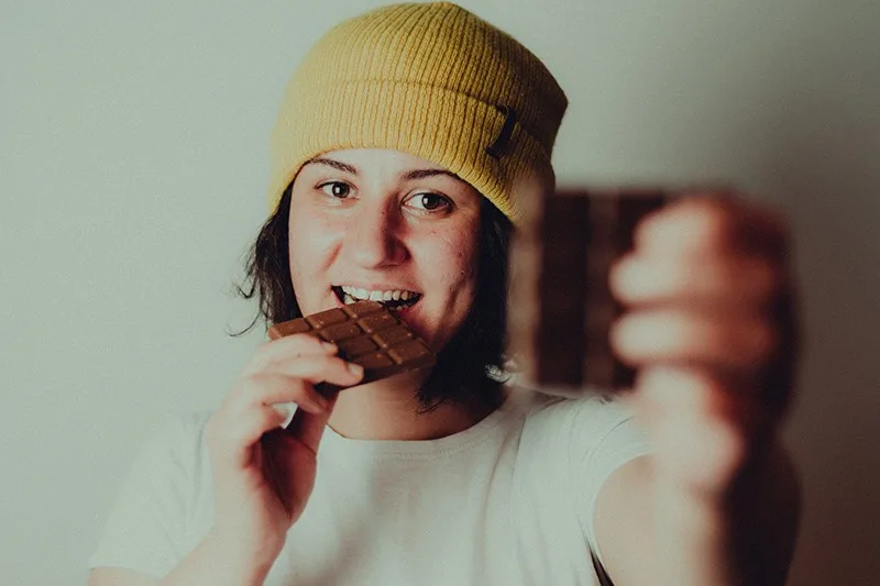  eine Frau Schokolade essen während es zeigt