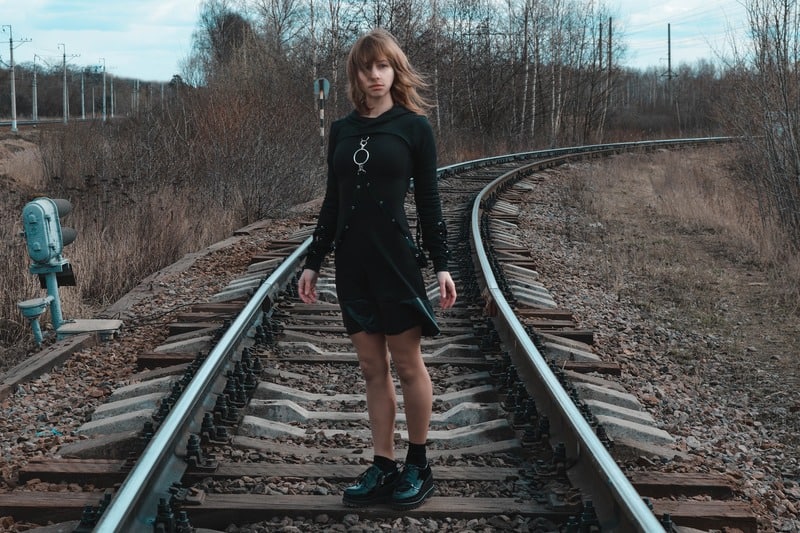 eine Frau auf einer Bahnstrecke