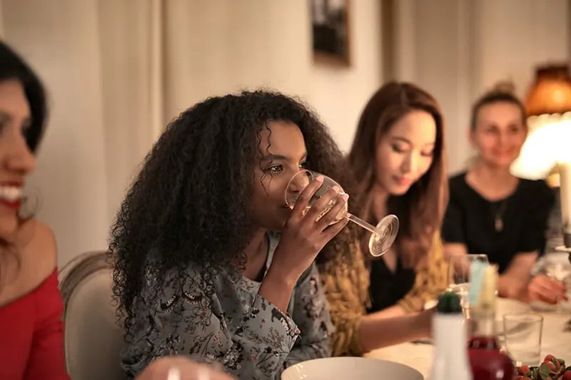 eine Frau, die mit Freunden Wein in einem Diner trinkt