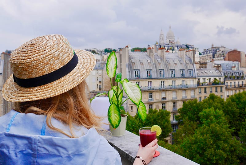  eine Frau, die alleine auf dem Balkon mit einem Drink in der Hand genießt
