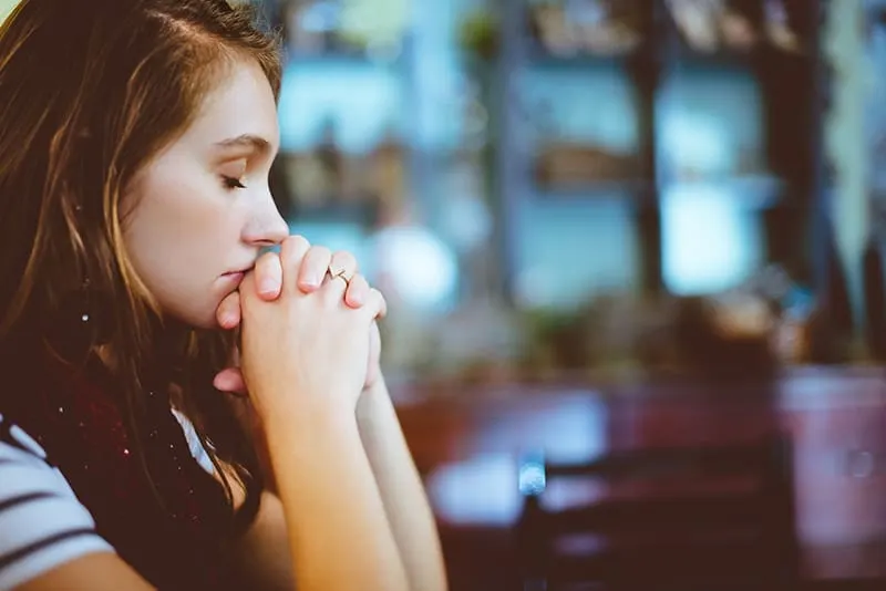 eine Frau, die mit geschlossenen Augen betet