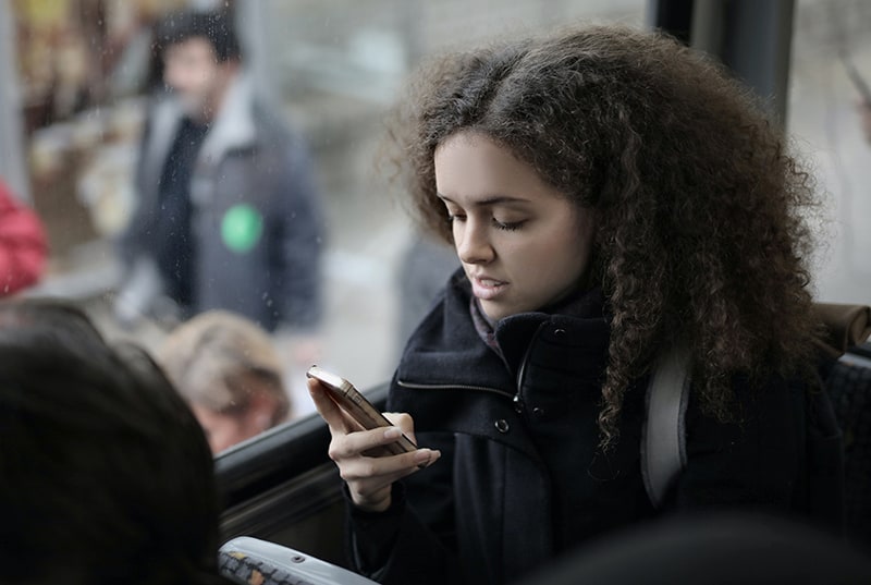 eine Frau, die einen Anruf ablehnt, während sie im Bus sitzt