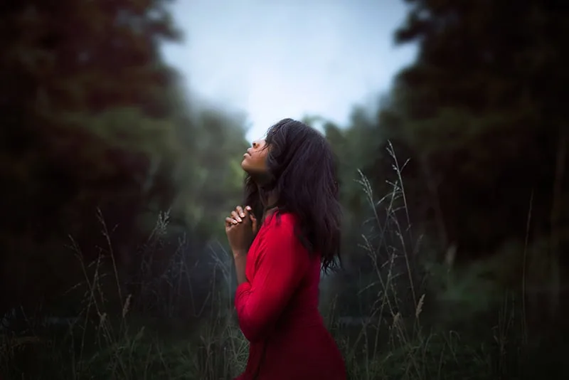 eine Frau, die beim Beten in den Himmel schaut