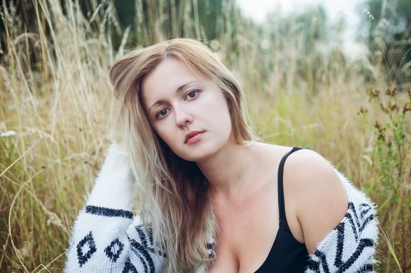 eine Frau mit blonden Haaren im hohen Gras