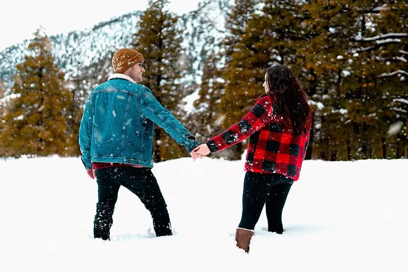 eine Frau und ein Mann, die ein Fotoshooting im Schnee haben