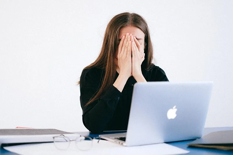 stressige Frau bedeckt ihr Gesicht Während der Arbeit